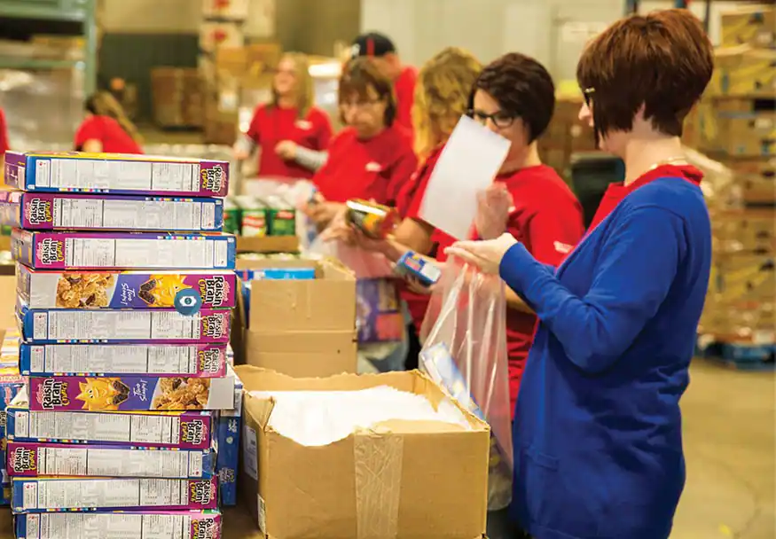 Kellogg volunteers assembling food for school feeding programs