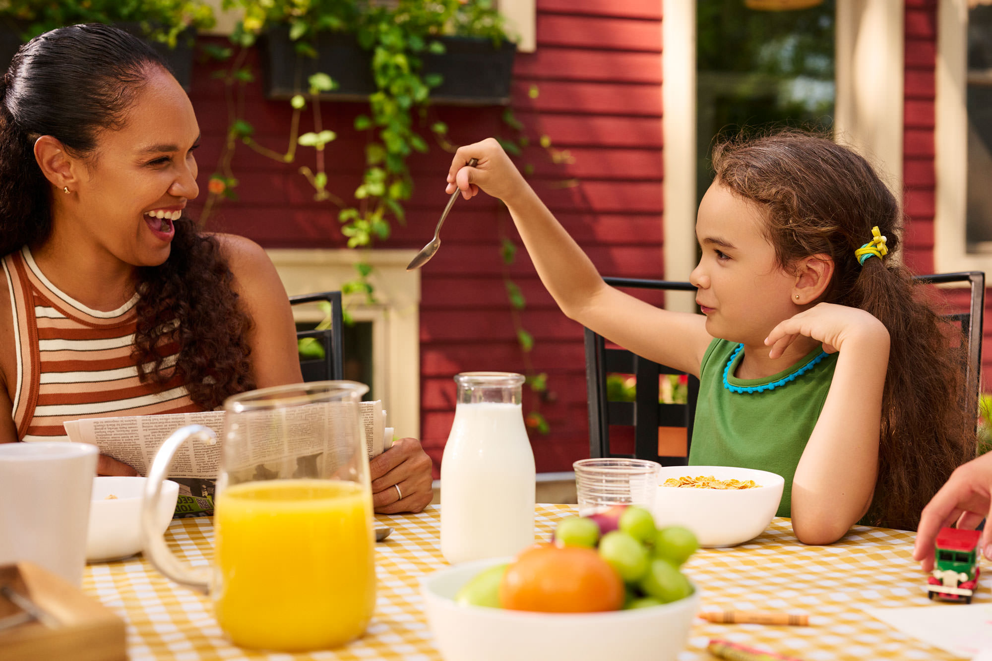 Mom and daughter sitting at breakfast laughing together